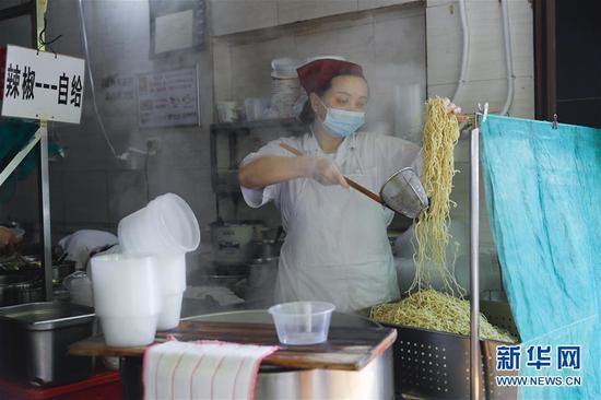 4月22日，武漢市糧道街的家陽“趙師傅”天天紅油熱干面店廚師在制作熱干面。新華社記者 沈伯韓 攝